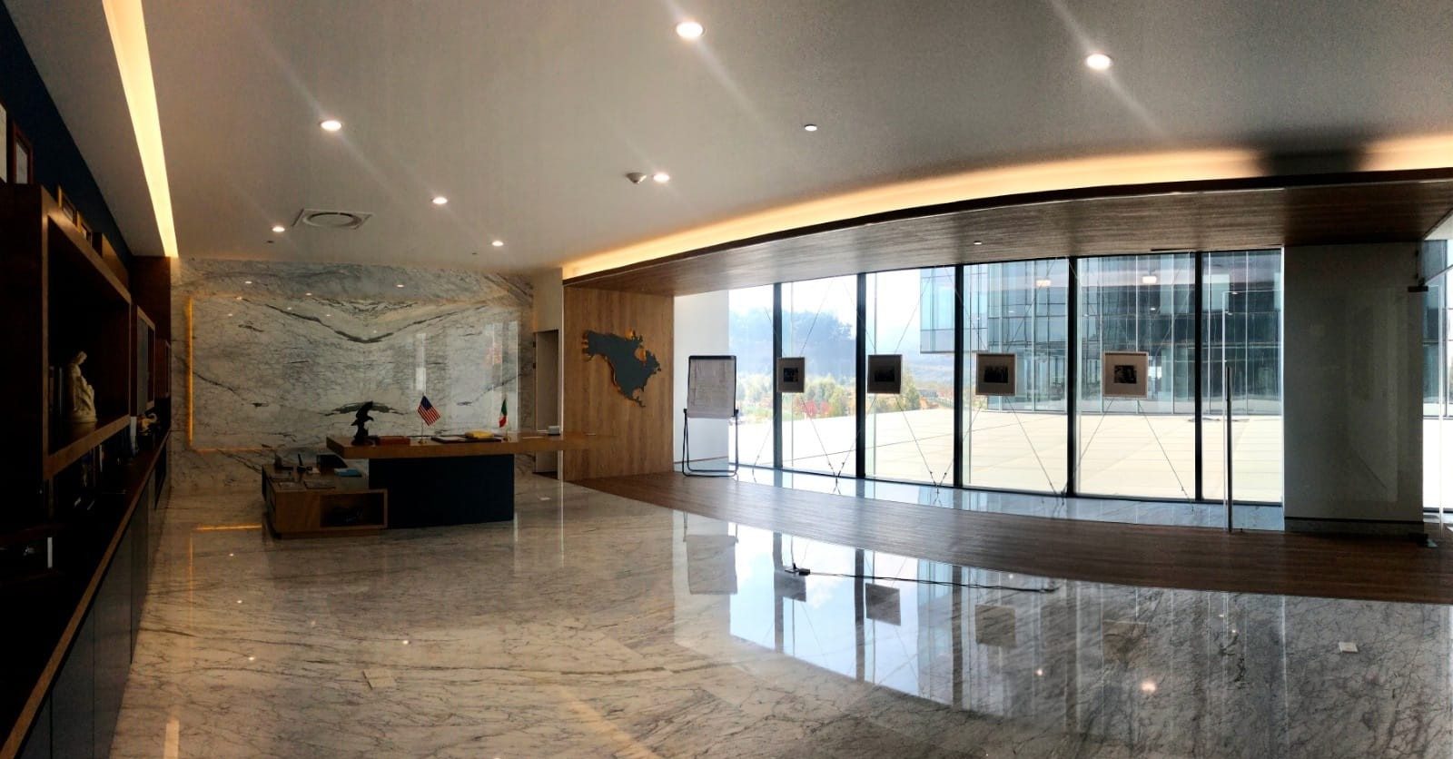 IL HQ: lobby ejecutivo con mármol, madera y ventanal de piso a techo